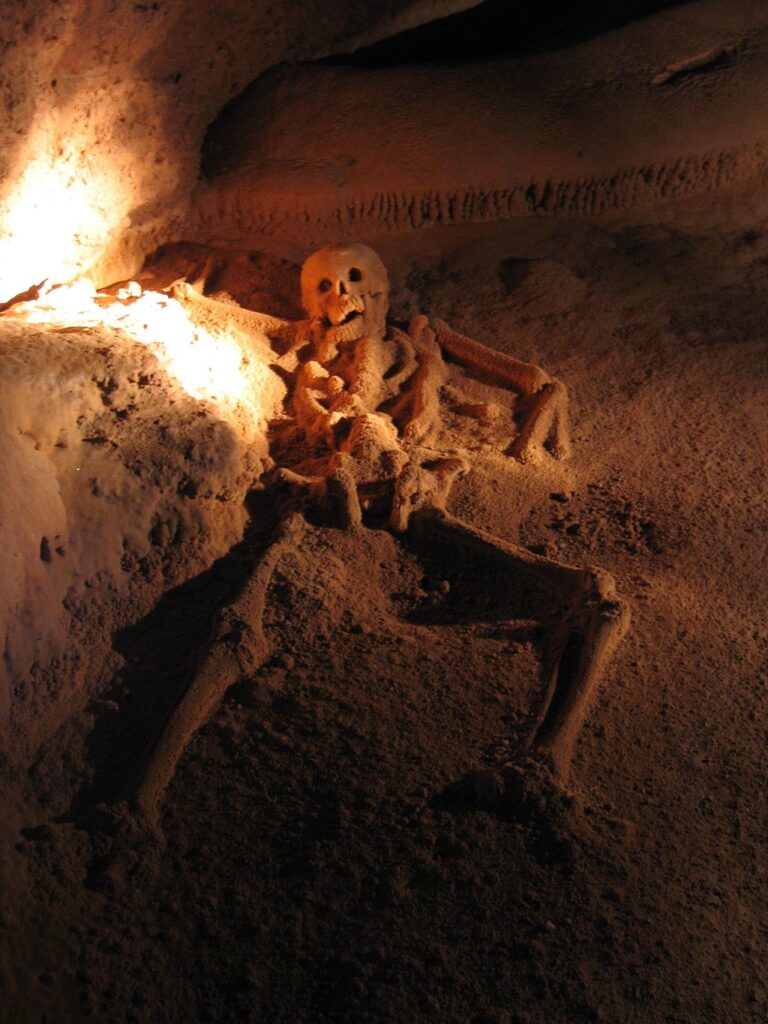 Crystal Maiden skeleton inside Actun Tunichil Muknal cave, Belize, illuminated by a soft light from feet to head.
