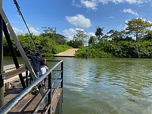 Two young boys standing on the Central Farm ferry crossing the Belize River