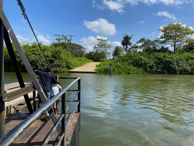 Two young boys standing on the Central Farm ferry crossing the Belize River