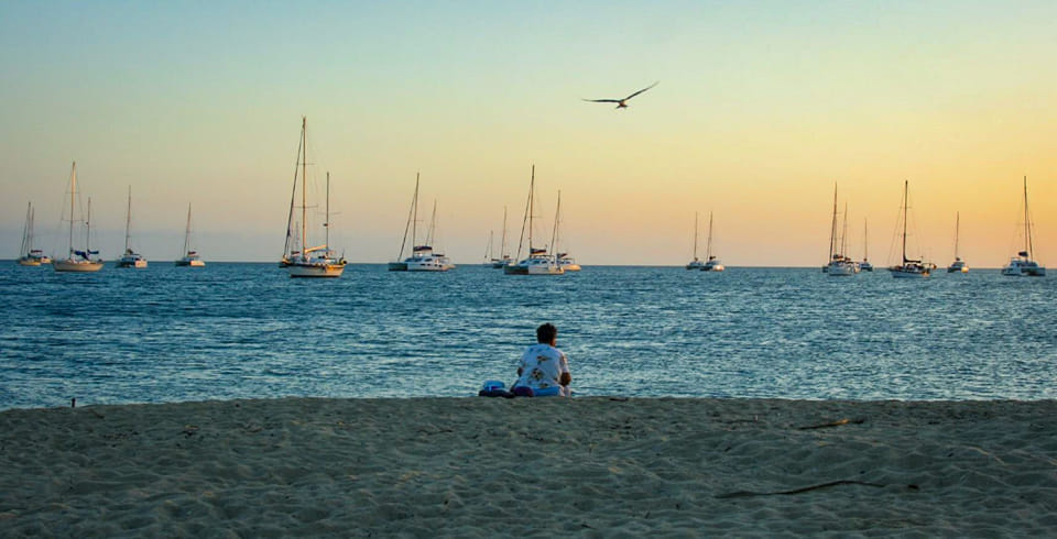 Ms. Elsie Leslie fishing at the point in Placencia, Belize, with sailboats in the harbour and a sunset sky, 2008 photo by Laura Godfrey