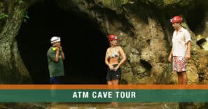 Guide and two guests standing at the entrance of the ATM Cave in Belize, preparing to begin their underground journey.
