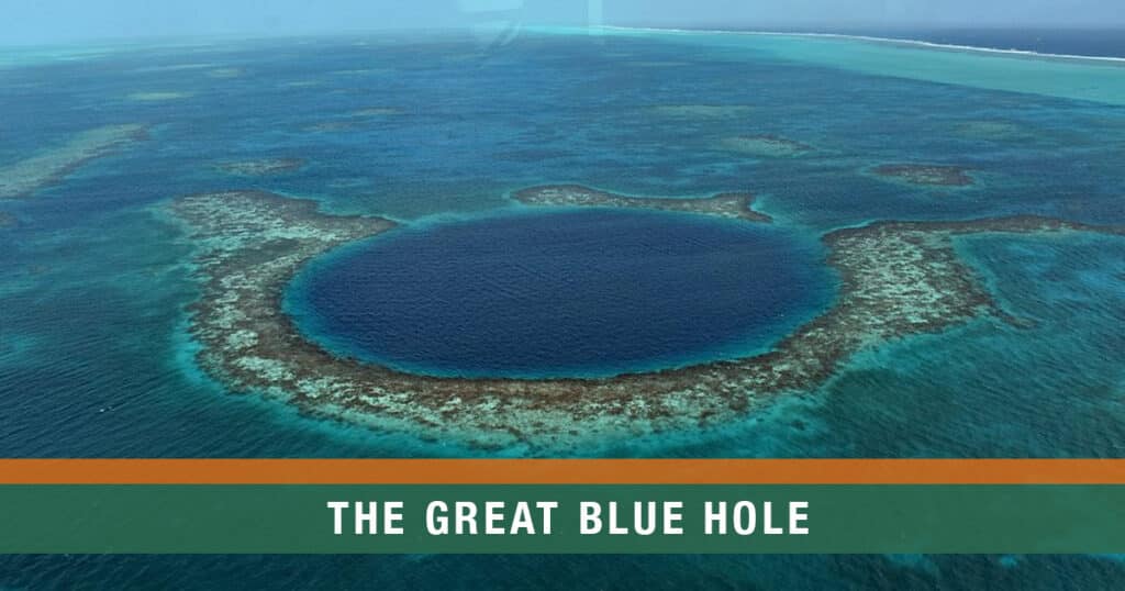Aerial view of the Great Blue Hole in Belize, showing the deep circular sinkhole surrounded by turquoise reef waters inside Lighthouse Reef Atoll.